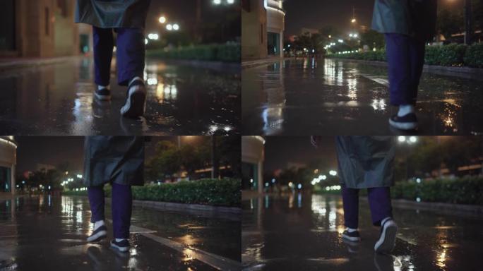 穿着雨衣的年轻人在倾盆大雨下站在马路上
