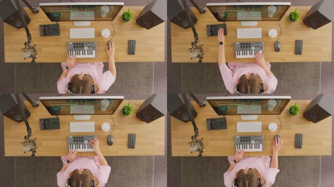 工作室中带有键盘和麦克风的工作站女音乐家的俯视图-慢动作拍摄