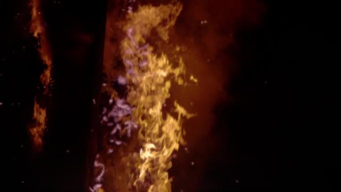 慢动作: 巨大的令人着迷的火焰，烟雾缠绕在燃烧的木头上