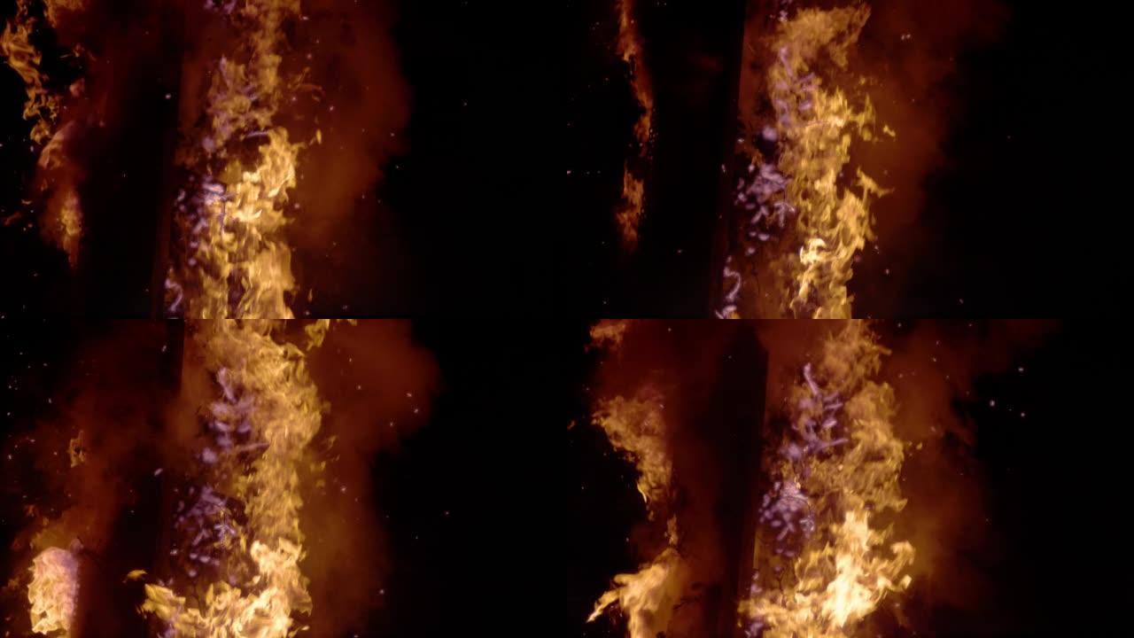 慢动作: 巨大的令人着迷的火焰，烟雾缠绕在燃烧的木头上