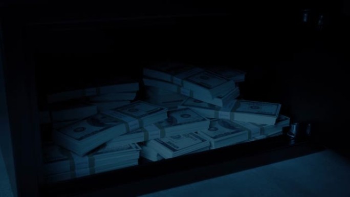 保险箱在黑暗的房间里打开和关闭，显示出很多钱