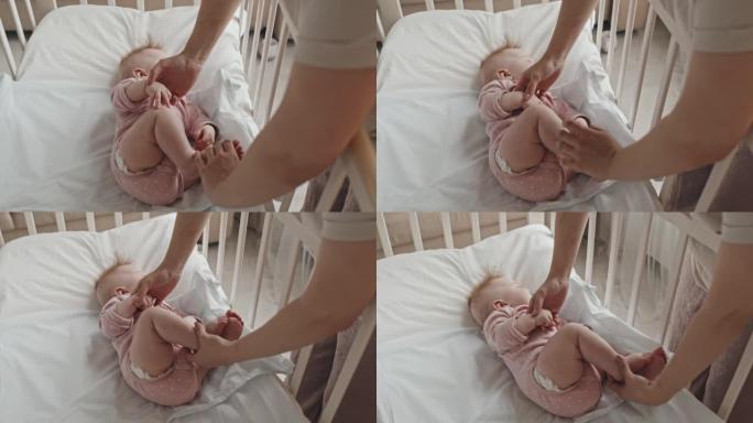 照顾者将婴儿放在婴儿床中