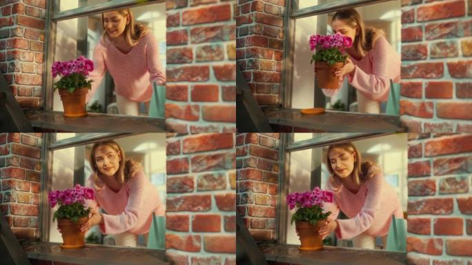 一位年轻女性在时尚公寓的窗台上浇水盆花的特写肖像。美丽的女孩拿起锅，享受华丽的粉红色花朵的气味。