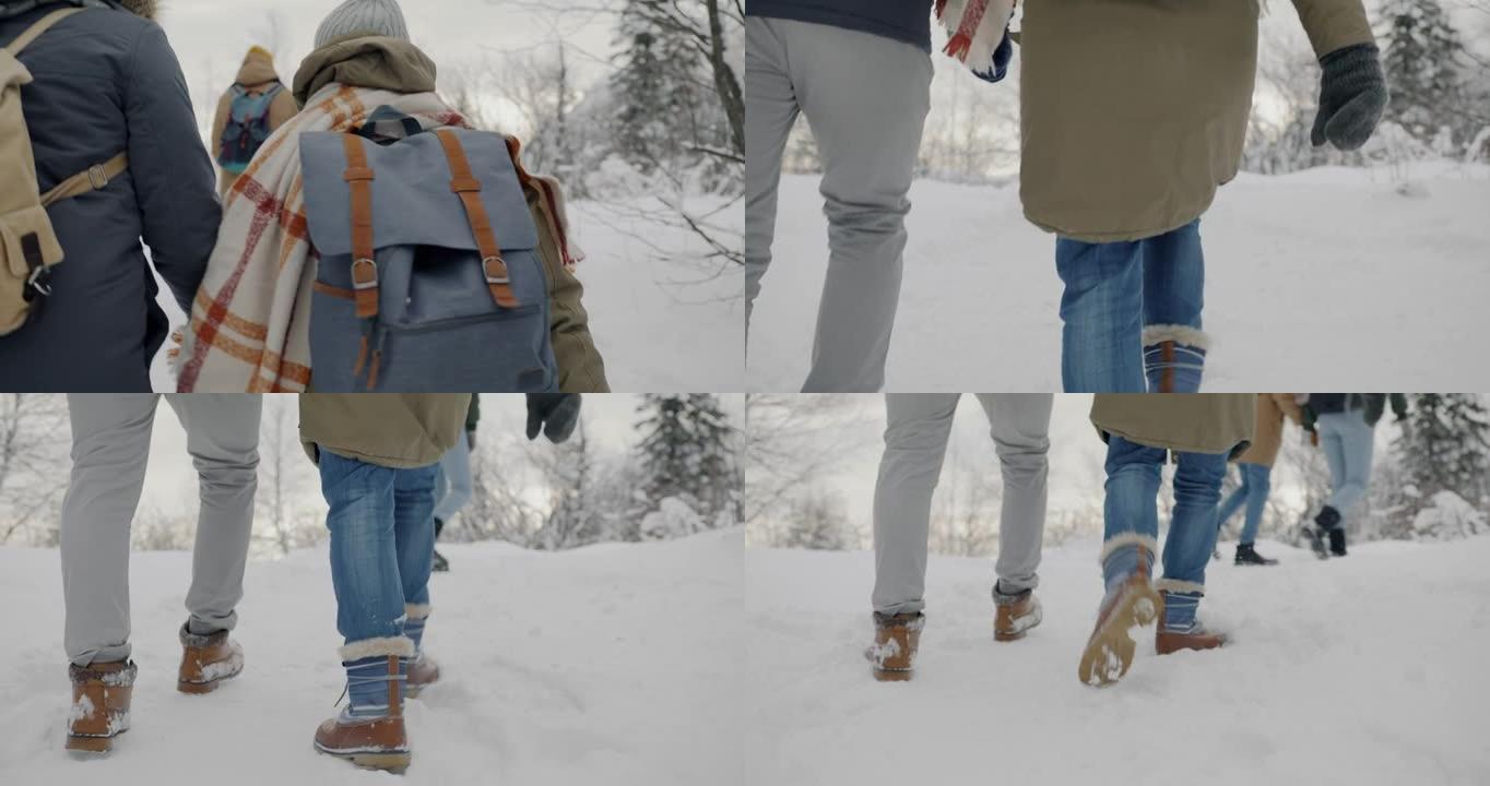 在冬季森林享受户外活动的雪地里散步的夫妇的后视图慢动作