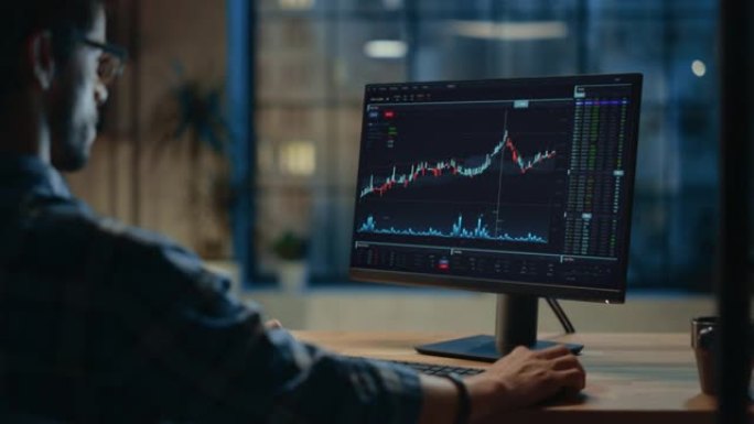 家庭办公室: 金融分析师使用计算机，显示器显示实时股票，商品，交易所市场图表。远程工作的西班牙商人进