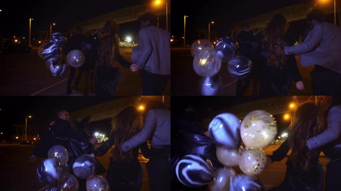 一群晚上带着气球在街上奔跑的朋友