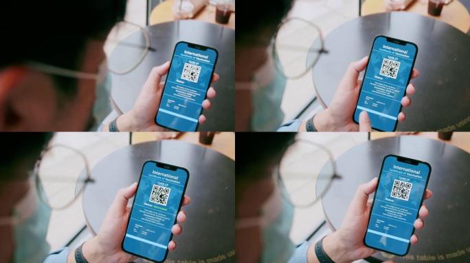 特写POV亚洲迷人男人微笑，同时拿着手机上的数字新型冠状病毒肺炎疫苗护照