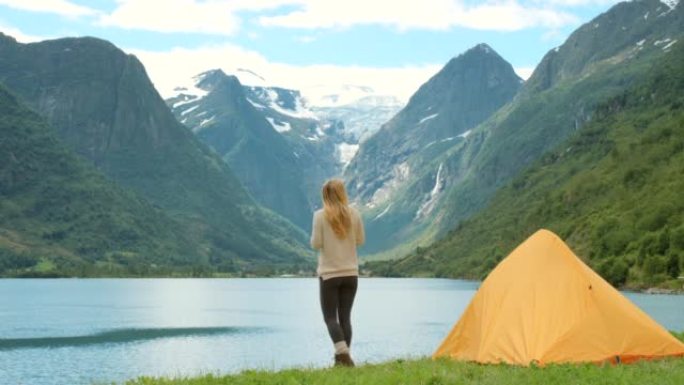 4k视频片段，一个无法识别的女人在Sogn og Fjordane附近露营时享受一杯咖啡