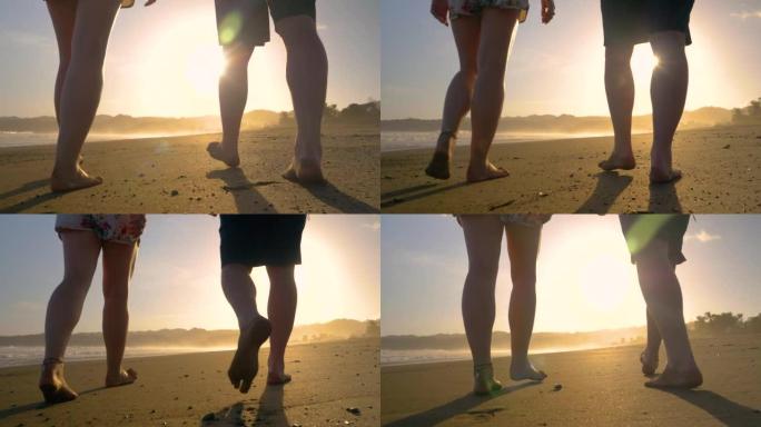 慢动作，低角度视图: 以下夫妇在沙滩上赤脚行走