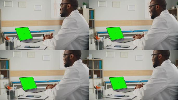 医生在线医疗咨询:非裔美国医生正在一台绿屏笔记本电脑上进行视频会议。医护人员向病人解释检查结果。