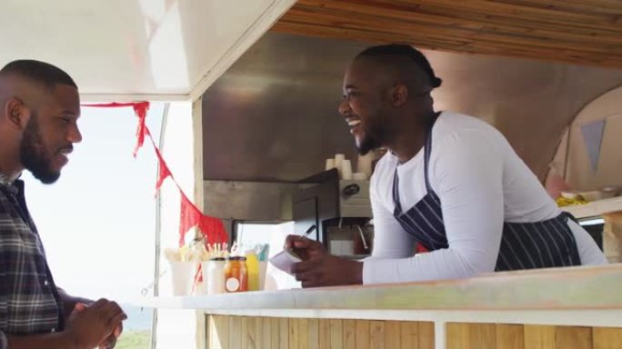 非裔美国男子穿着围裙在餐车上点菜