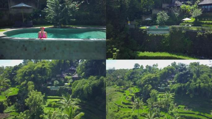 空中: 在巴厘岛度假的女性影响者从游泳池观察丛林。