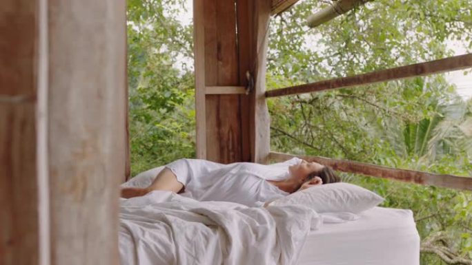 美丽的女人在酒店度假村的床上醒来，享受天堂4k的假期