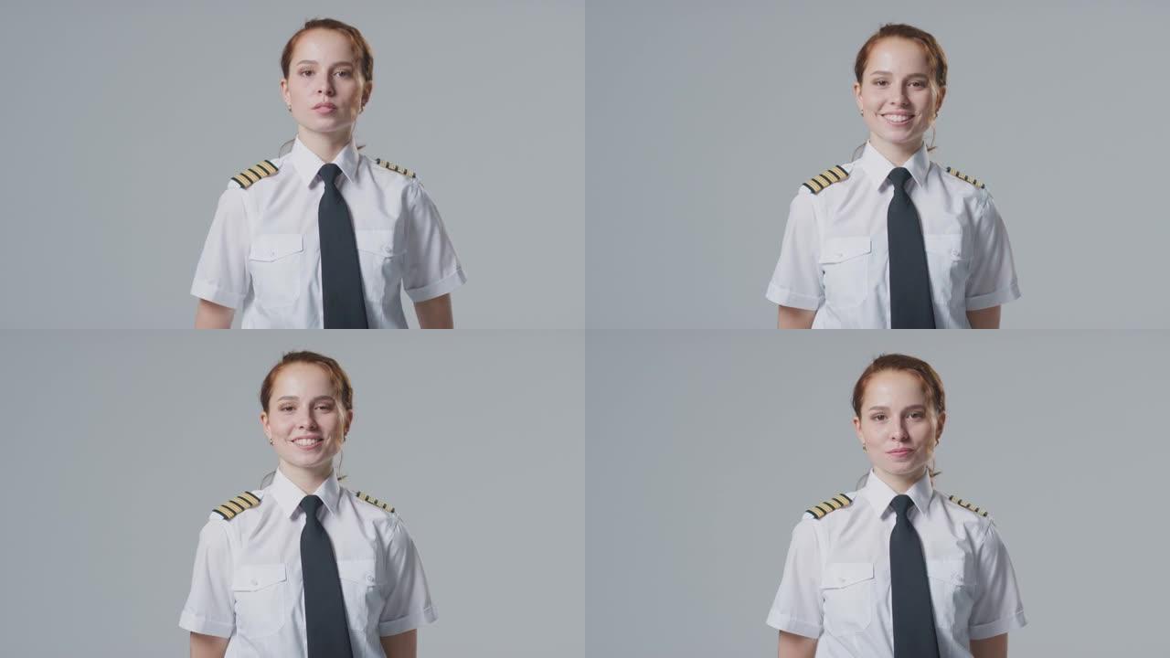 工作室在朴素的背景下微笑的女飞行员或船长的肖像
