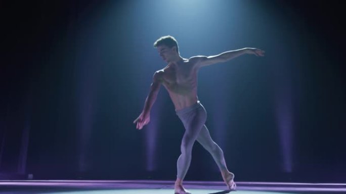 一位年轻的运动古典芭蕾舞男舞者的电影镜头正在演出开始前，在经典剧院舞台上用聚光灯进行编舞。