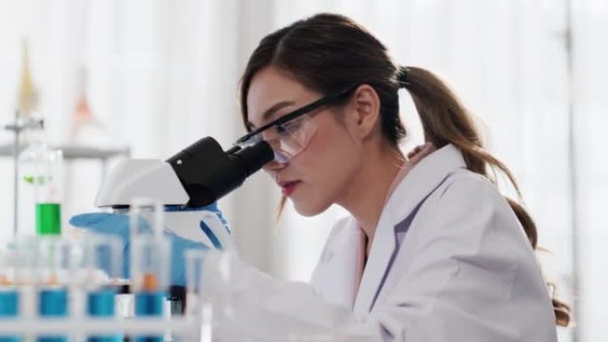 亚洲女科学家在实验室，显微镜测试和研究中工作