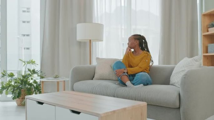 4k视频片段，一名年轻女子坐在家里的沙发上