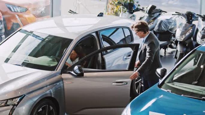 SLO MO成熟男汽车推销员向成熟女人展示新车的内饰