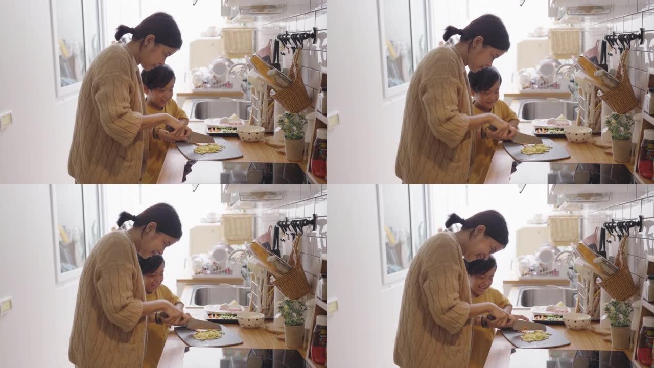 母亲和男孩在家在厨房做饭