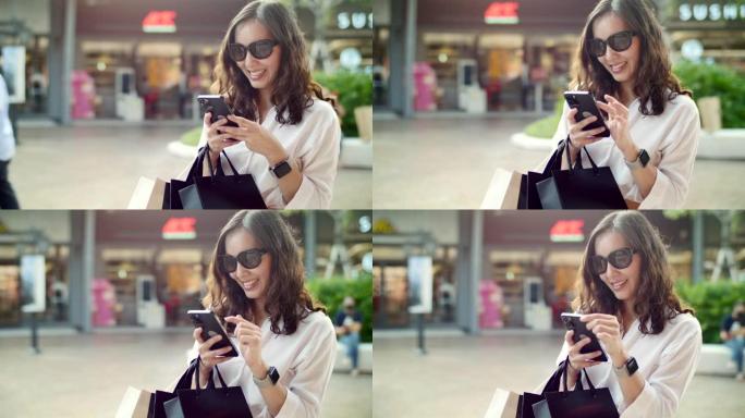 女人在购物中心购物，同时发短信和看零售展示