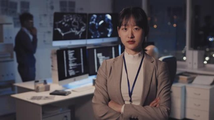 亚洲妇女在黑暗的IT办公室摆姿势