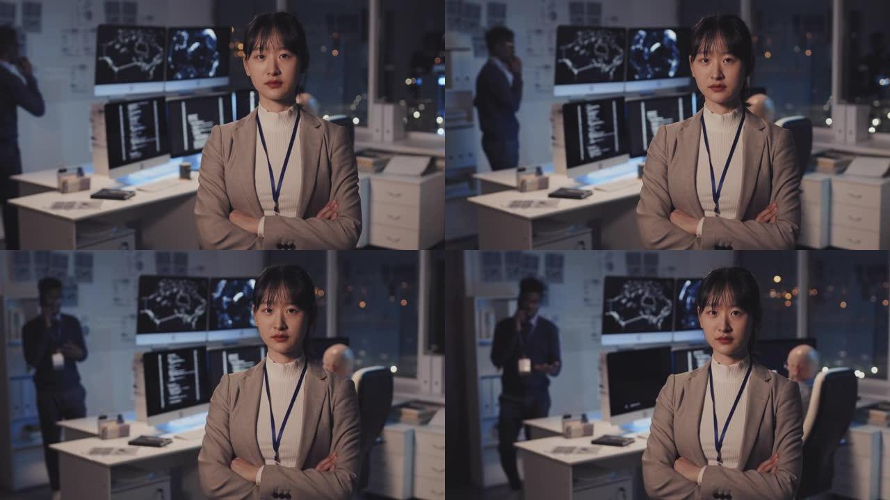 亚洲妇女在黑暗的IT办公室摆姿势