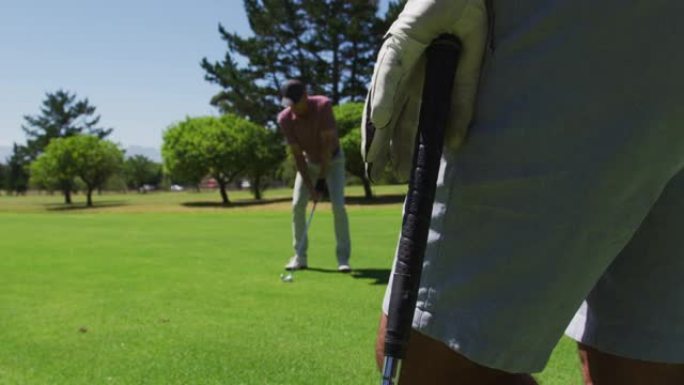 在阳光明媚的日子里，高加索资深男子在高尔夫球场练习高尔夫