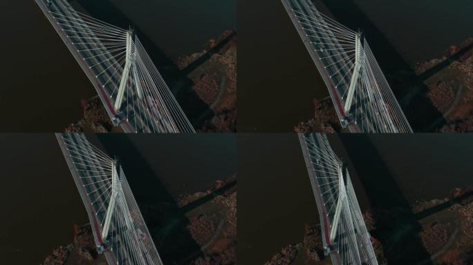 电影般的高角度空中拍摄，在阳光明媚的秋天日出时，汽车沿着令人惊叹的白色电缆桥穿过维斯拉河。