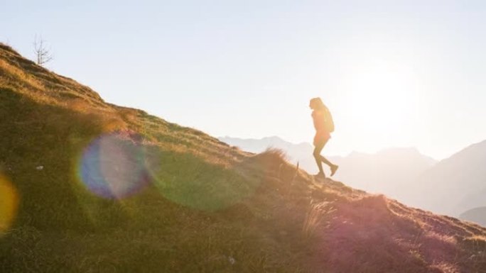 女性徒步旅行者走在山脊小径上，俯瞰下面雄伟的山谷