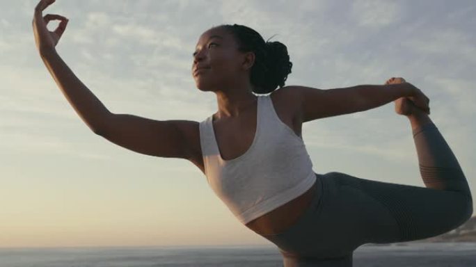 4k视频片段，一名年轻女子在海滩上摆瑜伽姿势