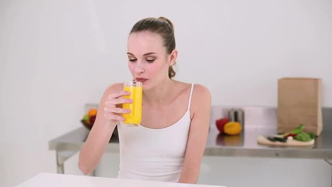 微笑的模特喝一杯橙汁