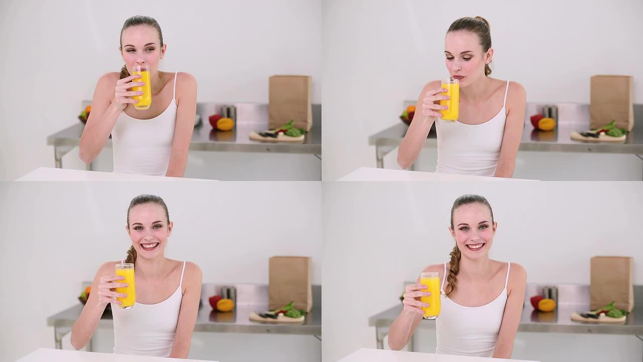 微笑的模特喝一杯橙汁