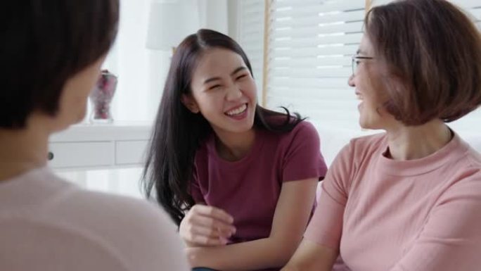 团体亚洲妇女坐在一起笑谈粉红色穿乳腺癌。