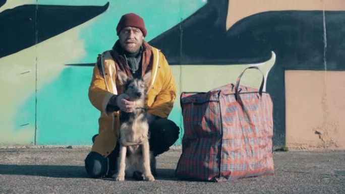 一个流浪汉正在用一个巨大的袋子抚摸他的狗