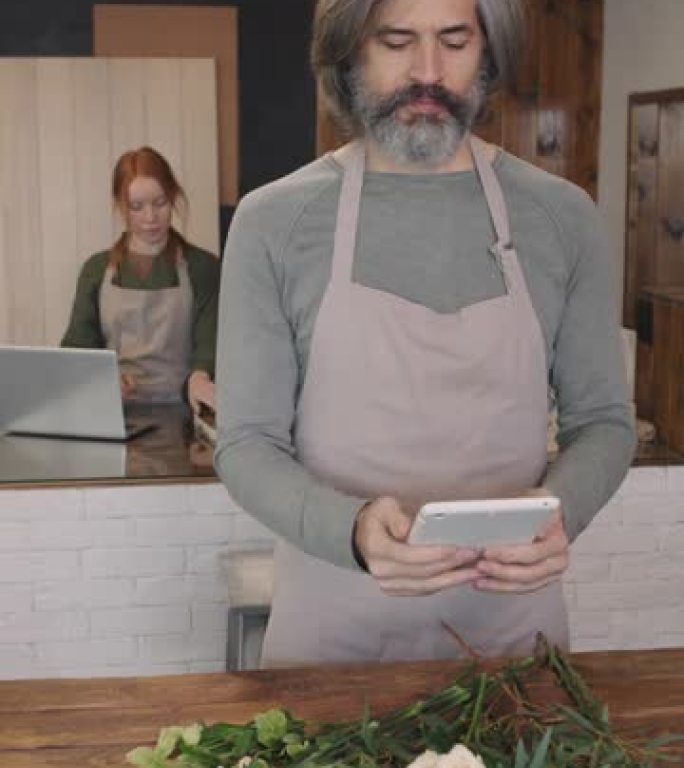手拿着数字平板电脑的男性花店肖像