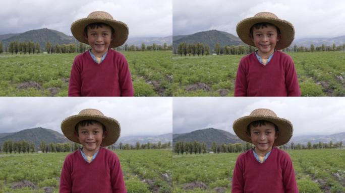 可爱的小男孩在土豆收割场高兴地对着镜头微笑