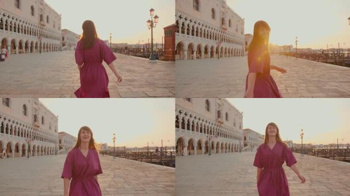 镜头跟随美丽快乐的年轻白人妇女旋转，沿着意大利威尼斯历史悠久的日出街散步。