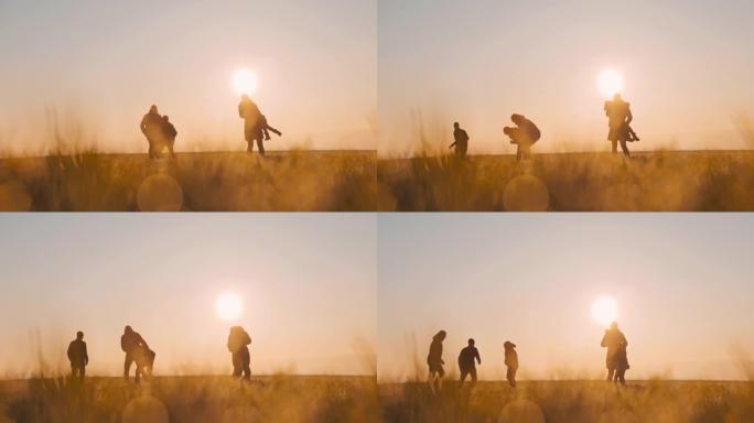 SLO MO WS家庭和三个孩子在日落时在草地上度过快乐的时光