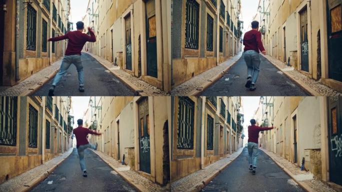 在城市老城区的街道上散步时，开朗快乐的成年男子穿着便服积极跳舞。在城市安静的狭窄城镇街道上拍摄的场景