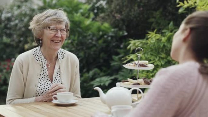 一个祖母和孙女在外面的花园里举行茶会的4k录像