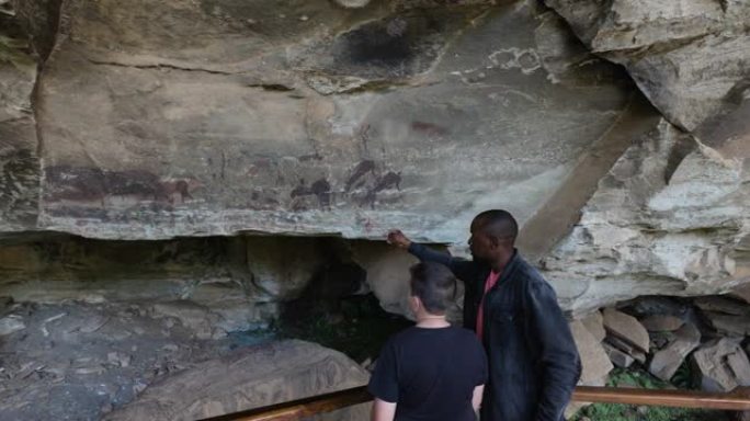 南非夸祖鲁-纳塔尔省德拉肯斯堡巨人城堡内，导游带领游客参观保存完好的圣布希曼绘画