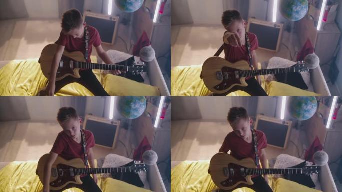 青少年摇滚歌手在床上弹吉他