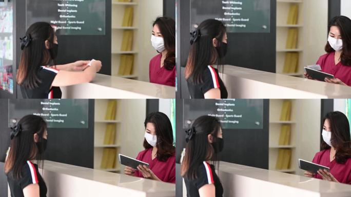 亚洲华人患者在牙医诊所接待处登记口罩新常态