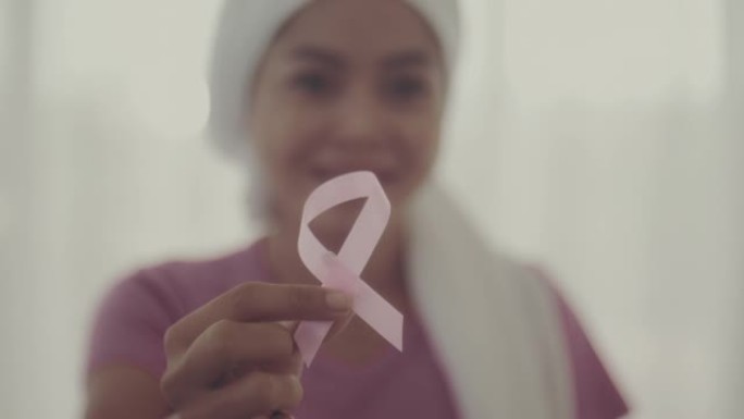女子手持粉红丝带，乳腺癌