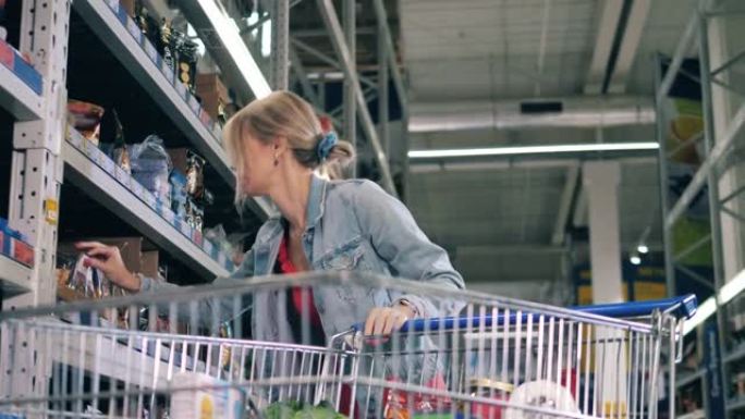 一位女士在超市购物时正在选择杂货