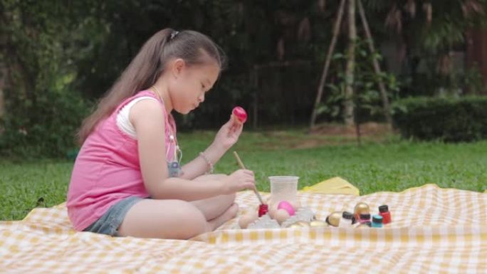 亚洲女孩为复活节画鸡蛋