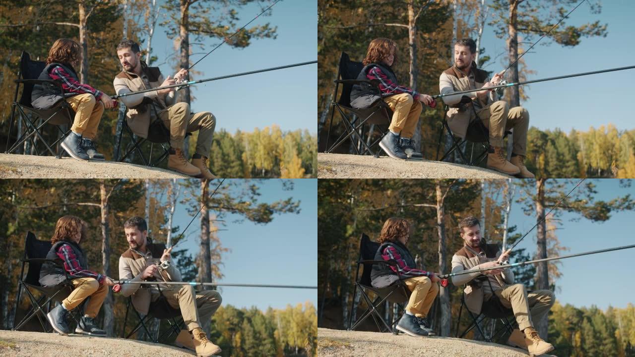 父亲和儿子在秋天的日子坐在河岸的椅子上钓鱼和聊天