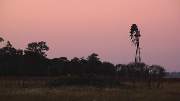 农场日落时的旧风轮。