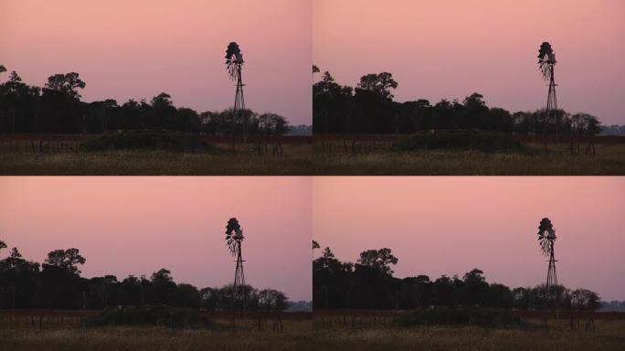 农场日落时的旧风轮。