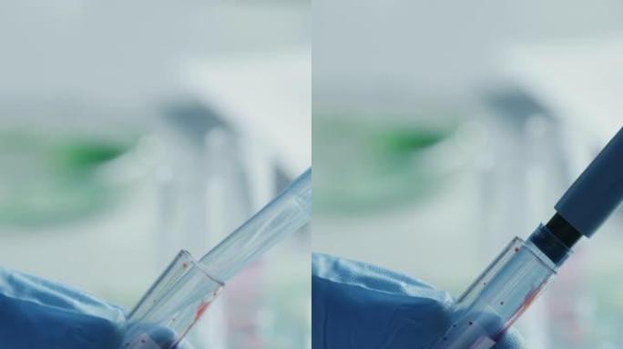 科学家使用微量移液器并将红色化学液体或血液在显微镜上进行测试的垂直格式的镜头。用技术设备在实验室工作